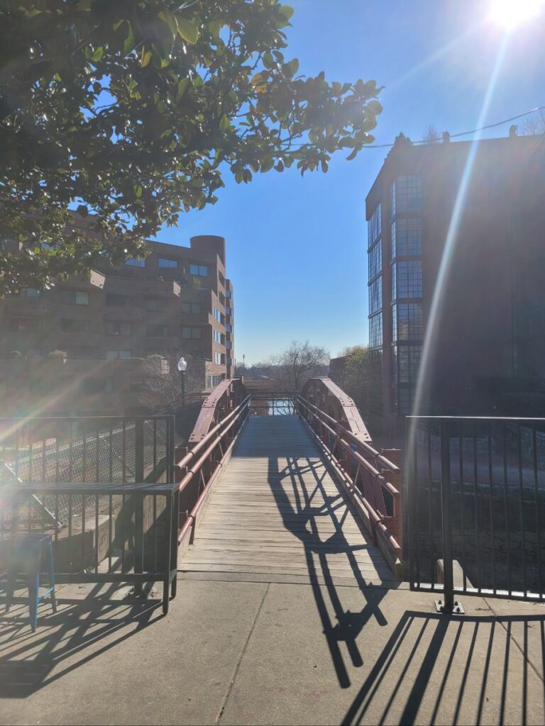 Bridge over the canal in morning light, casting soft shadows.